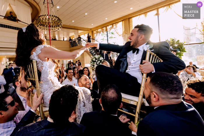 Illinois best wedding photography from Victoria in the Park showing a pic of the  dance floor chair dance action with the bride and groom