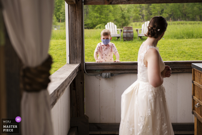 A melhor fotografia de casamento de Massachusetts na Valley View Farm em Haydenville, mostrando uma foto de um jovem convidado na recepção com a noiva em primeiro plano