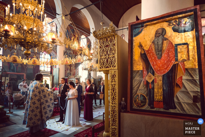 Beste Hochzeitsfotografie aus Bulgarien, die ein Bild einer kirchlichen Zeremonie im Innenbereich zeigt