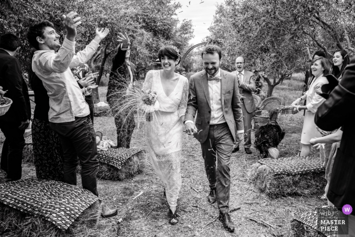 Beste huwelijksfotografie uit Occitanie met een foto van de bruid en bruidegom die de seculiere ceremonie verlaten onder applaus van hun gasten