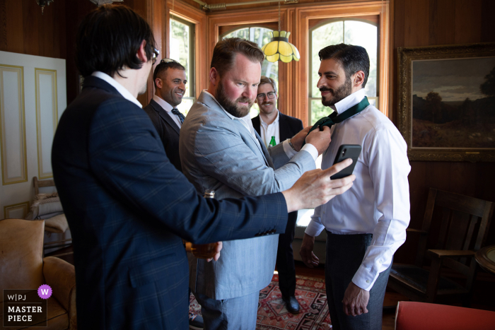 Um fotógrafo de casamento da Switzer Farm em Mendocino, Califórnia, criou esta imagem de padrinhos amarrando a gravata dos noivos usando a internet como guia