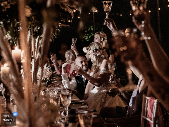 Een Italiaanse trouwfotograaf bij Villa Lattuada heeft deze afbeelding gemaakt van A toast tijdens het diner