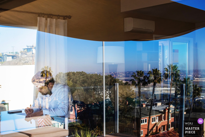 A wedding photographer at the Sunset Cliffs in San Diego created this image showing groom writes down vows during before sunset cliffs ceremony