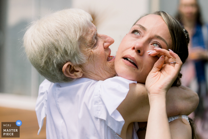 A wedding photographer in Vendee created this image showing The bride embraces her grandmother after covid pandemics and cries  