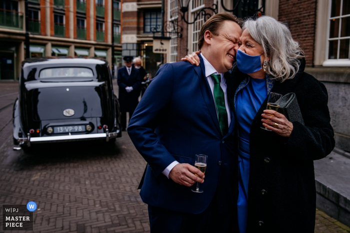 Beste Hochzeitsfotografie aus den Niederlanden, die ein Bild des Bräutigams mit seiner Mutter nach der Zeremonie zeigt