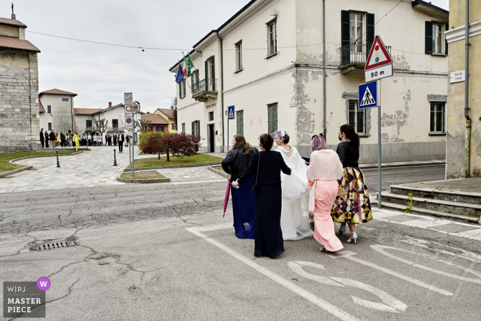 Ein Hochzeitsfotograf in Brebbia hat dieses Bild der Ankunft der Braut auf der Straße erstellt