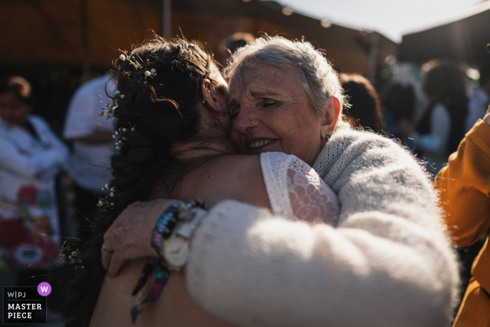 Photographie de mariage de Quiberon, France montrant un câlin entre la mariée et sa grand-mère