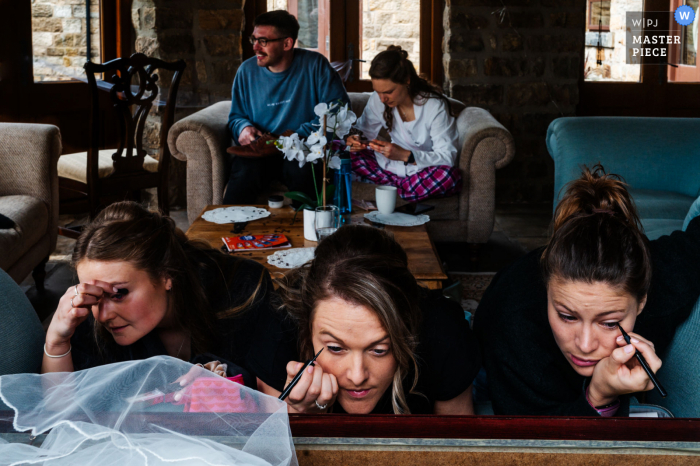 Un cottage nello Yorkshire, Regno Unito, fotografia di reportage di matrimonio che mostra la sposa e la sua festa nuziale prepararsi in un'intensa mattinata di nozze