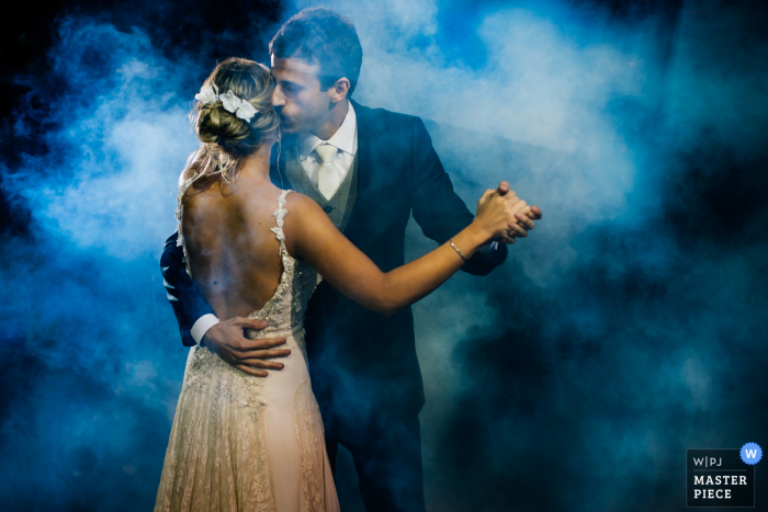 Imagen de la boda de Rio Grande do Sul de novios bailando bajo luces azules y niebla