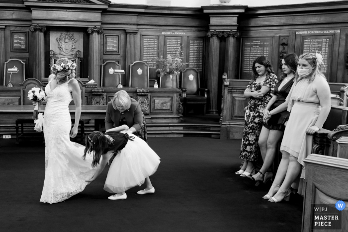 Hackney Town Hall indoor marriage ceremony award-winning image showing the Last minute alterations in black and white. The world's best wedding picture competitions are featured via the WPJA