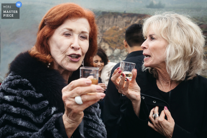 Big Sur, CA outdoor wedding image of Mother and grandmother of the groom taking shots.