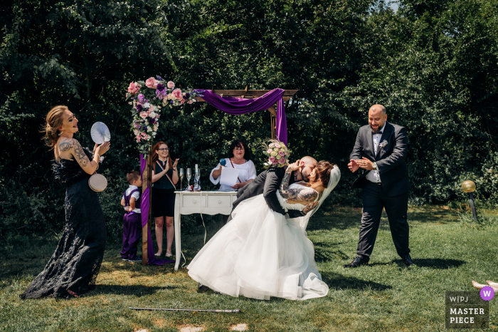 Imagem premiada da cerimônia de casamento ao ar livre de Sofia, Bulgária, mostrando o primeiro beijo ao ar livre sob as árvores com um tom românico. Os melhores concursos de fotos de casamento do mundo apresentados pela WPJA