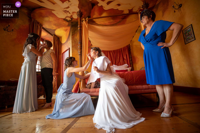 Occitanie tiempo de preparación del matrimonio foto ganadora de premios que captura el retoque de maquillaje antes de la iglesia después de mucha emoción. Los mejores concursos de imágenes de bodas del mundo los organiza la WPJA