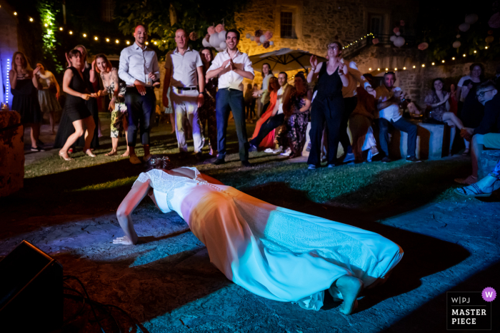 Montpellier, Frankrijk bekroonde foto van een huwelijksreceptie in de buitenlucht waarop de bruid tijdens de bruiloft push-ups doet. 'S Werelds beste trouwfotografen strijden tegen de WPJA