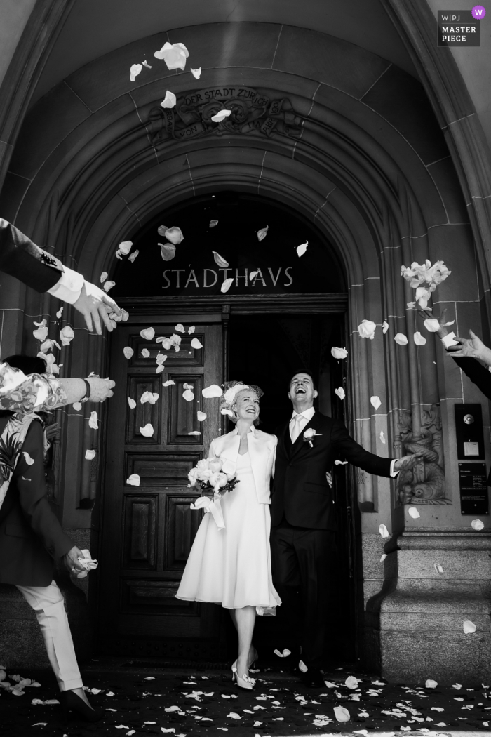 Suiza imagen galardonada del día nupcial de la novia y el novio celebrando bajo duchas de pétalos de flores