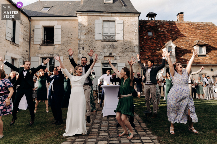 Château d'Allogny - Indre Outdoor-Hochzeitsempfangsparty preisgekröntes Foto, das einen Überraschungstanz der Gäste für das Brautpaar aufgenommen hat. Sie schlossen sich ihnen am Ende des Liedes an, um mit ihren Freunden zu genießen