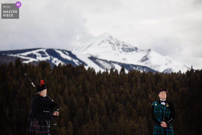 Big Sky, Montana, imagem premiada do dia nupcial do noivo ficando emocionado ao ouvir o gaiteiro antes da procissão. Os melhores concursos de fotografia de casamento do mundo são organizados pela WPJA