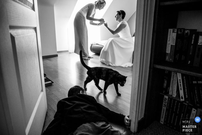 Foto premiada do tempo de preparação do casamento na Bretanha, capturando uma criança no chão enquanto a noiva se arruma. Os melhores concursos de imagens de casamento do mundo são realizados pela WPJA