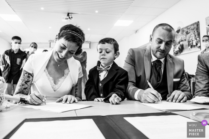 Brittany indoor marriage ceremony award-winning image showing the bride and grooms son when the couple sign