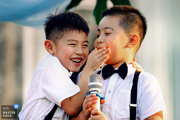 Foto ganadora de un premio en la fiesta de recepción de matrimonio al aire libre de Nanning que ha grabado a un niño divertido en el momento del micrófono