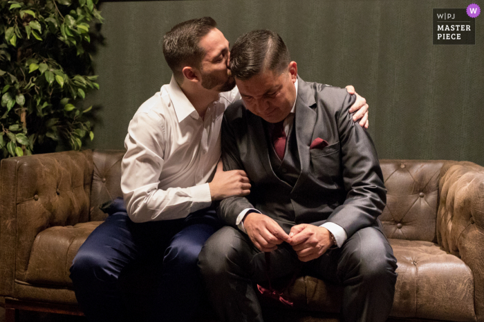 Sao Paulo nuptial day award-winning image of the groom and his father in an emotional hug. The world's best wedding photography competitions are hosted by the WPJA