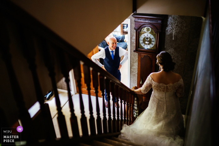 Whitchurch, Großbritannien, preisgekröntes Bild für die Hochzeitsvorbereitungszeit, das den Vater der Braut zeigt, der seine Tochter in ihrem Hochzeitskleid sieht. Die weltbesten Hochzeitsbildwettbewerbe werden von der WPJA veranstaltet