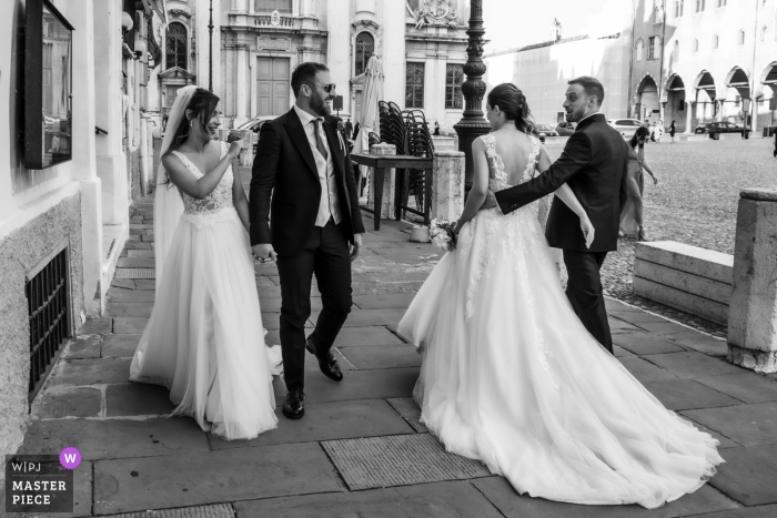Photo by: <a href="https://www.wpja.com/contests/2021-v02/best-wedding-photographers/2631390">Fabrizio Demasi - Gonzaga Mantova</a> Piazza Sordello - Mantova nuptial day award-winning image of a Casual meeting with another married couple during reportage shots in the city.