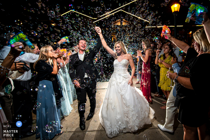 Foto ganadora de premios de la fiesta de recepción de matrimonio al aire libre de Estes Park Resort, Colorado que ha grabado una despedida de la burbuja de los novios