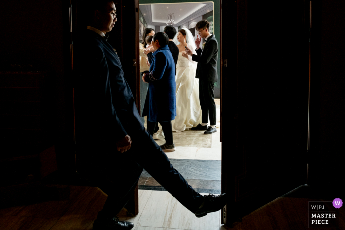 Image primée de la cérémonie de mariage en salle du Sichuan montrant La cérémonie de mariage est sur le point de commencer. C'est la porte par laquelle la mariée entre dans l'auditorium au début de la cérémonie. Le témoin ferme la porte pour préparer la cérémonie.