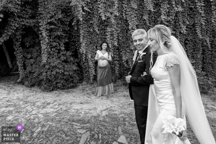 Riserva Naturale Orientata La Timpa cérémonie de mariage en plein air image primée montrant Ces époux marchent le long d'un sentier naturel et une femme qui attend de devenir mère les regarde d'un air satisfait alors qu'ils passent devant eux.