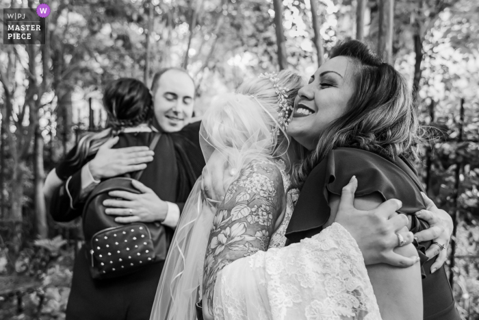 Photo by: <a href="https://www.wpja.com/contests/2021-v02/best-wedding-photographers/2631730">Cindy Brown - Atlanta Georgia</a> Kehoe House, Savannah, Georgia nuptial day award-winning image of Double hug in black in white outdoors