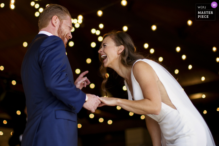 Foto vencedora do prêmio de casamento ao ar livre do Sanctuary Golf Course que gravou A noiva e o noivo rindo durante a cerimônia