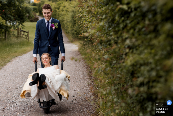 Chiltern Open Air Museum, UK nuptial day award-winning image of the Bride being ferried to reception in wheel barrow