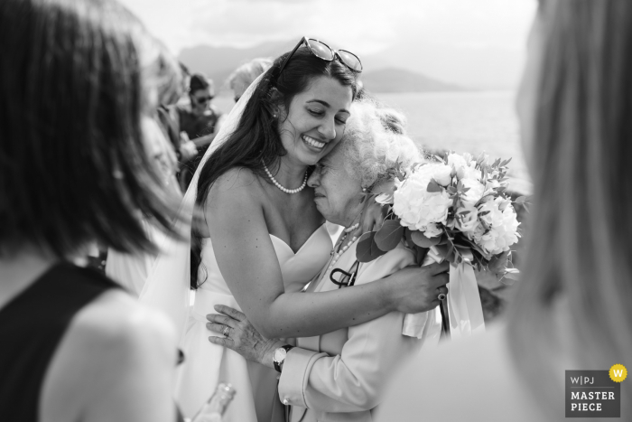 Imagem premiada da cerimônia de casamento ao ar livre no Lago Maggiore, Itália, mostrando a noiva abraçando a avó