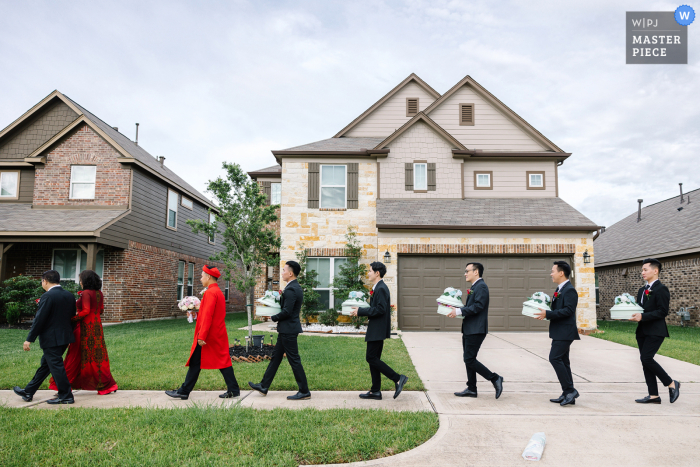 Bekroond beeld van de huwelijksdag in Texas van de bruidsjonkers die de bruidegom helpen om geschenken aan de familie van de bruid te brengen. 'S Werelds beste huwelijksfotografiewedstrijden worden georganiseerd door de WPJA