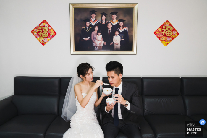 Image primée du jour des noces de Singapour de la mariée donnant une boule de riz à son époux lors d'une cérémonie chinoise