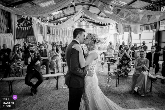 Humble by Nature, Upper Meend Farm, Monmouth indoor marriage ceremony award-winning image showing the First kiss as Mr and Mrs Humble by Nature, Upper Meend Farm, Monmouth indoor marriage ceremony award-winning image showing the First kiss as Mr and Mrs