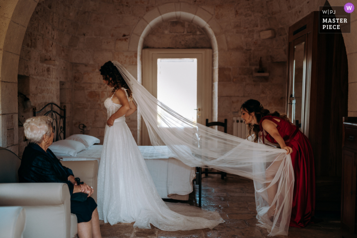 Tiempo de preparación para el matrimonio de Puglia foto ganadora de premios que captura a la novia arreglando el velo