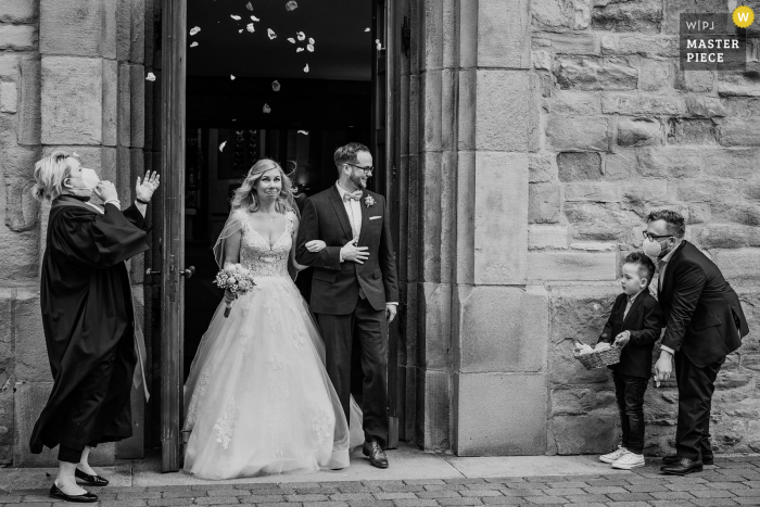 Imagen ganadora del premio del día nupcial de Dortmund del confeti de flores cuando los novios salen de la iglesia