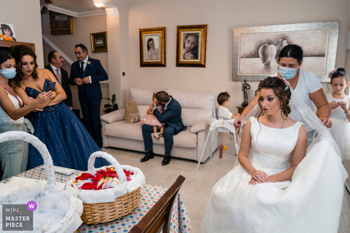 Jaén, España tiempo de preparación para el matrimonio foto premiada capturando a la novia preparándose en una habitación llena de gente