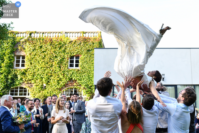 Photo by: <a href="https://www.wpja.com/contests/2021-v02/best-wedding-photographers/2632219">Mehdi Djafer - Lille Nord (59) </a> Lille outdoor marriage reception party award-winning photo that has recorded the bride’s relatives trying to throw her in the air