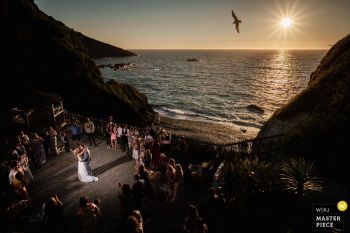 Photo primée de la réception de mariage en plein air de Tunnels Beaches qui a enregistré une première danse au coucher du soleil au bord de l'océan