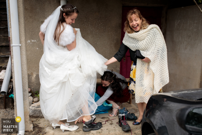 Pont de la Mariée Hochzeitsvorbereitungszeit preisgekrönte Bildaufnahme Die Braut wechselt ihre Hochzeitsschuhe gegen Wanderstiefel