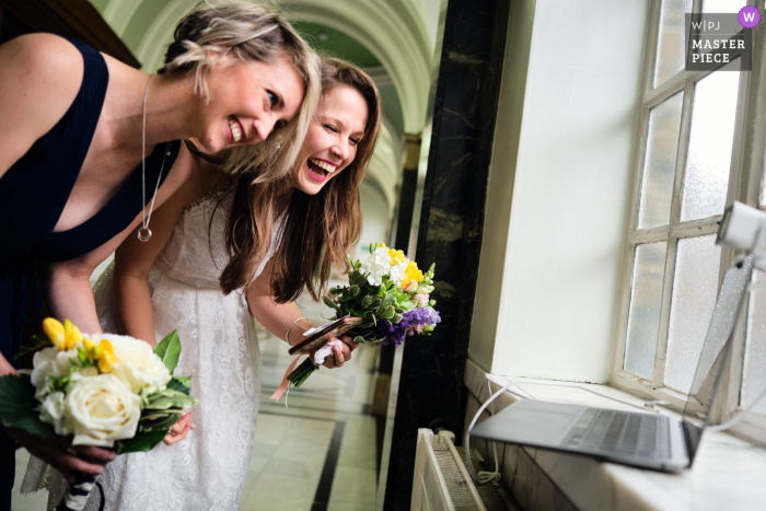 Photo by: <a href="https://www.wpja.com/contests/2021-v02/best-wedding-photographers/2632351">Wayne La - London London</a> Islington Town Hall, London nuptial day award-winning image of goodbyes to their families on Zoom