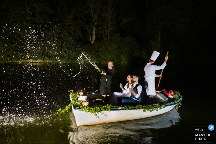 Bretagne, Rennes preisgekröntes Foto der Hochzeitsfeier im Freien, das die Ankunft von Kuchen und Champagner über ein Boot festhält. Die besten Hochzeitsfotografen der Welt messen sich bei der WPJA