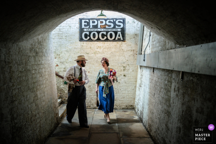 Bluebell Railway, Sussex, Reino Unido día nupcial imagen galardonada de la novia y el novio caminando a su ceremonia en una antigua estación de tren