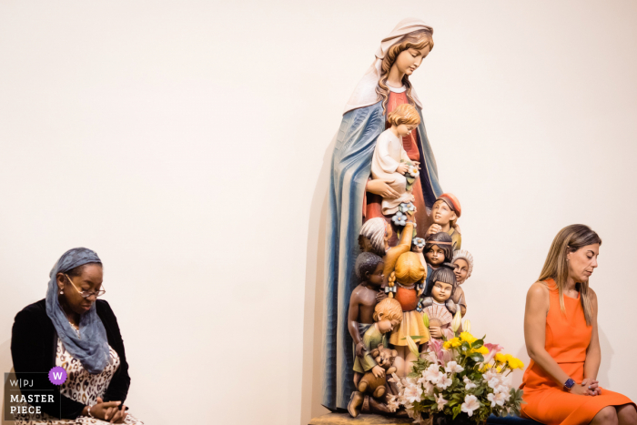 Virginia indoor marriage ceremony award-winning image showing guests seated and a statue in the church