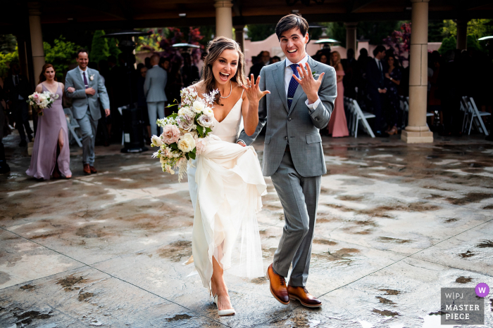 The Broadmoor Hotel, Colorado Springs nuptial day award-winning image of The couple showing off their new rings while striding in unison.