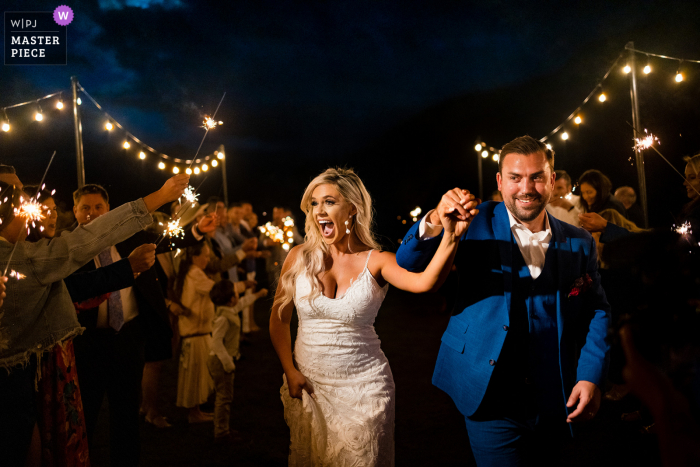 Foto premiada da festa de recepção de casamento ao ar livre em Camp Hale, Redcliffe, Colorado que gravou O casal terminando seu casamento com uma despedida.