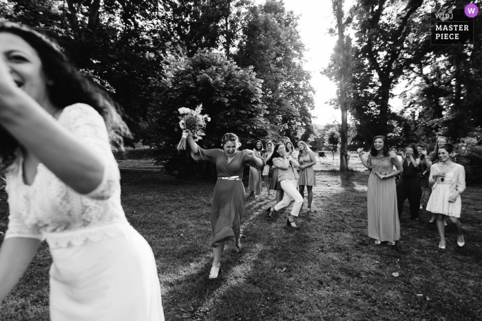 Foto ganadora de premios de la fiesta de recepción de matrimonio al aire libre de Beaujolais que ha grabado el juego del ramo en BW. Los mejores fotógrafos de bodas del mundo compiten en la WPJA